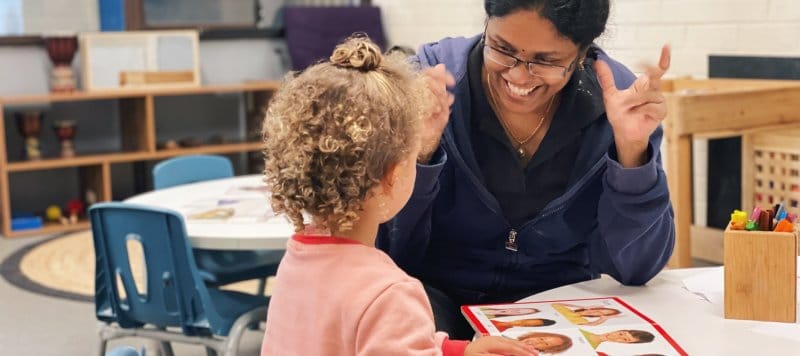 An educator teaches a child about facial expressions