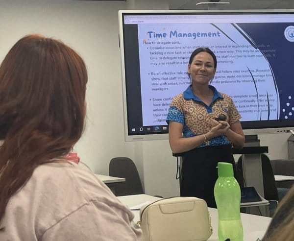 A woman smiles and talks about team management